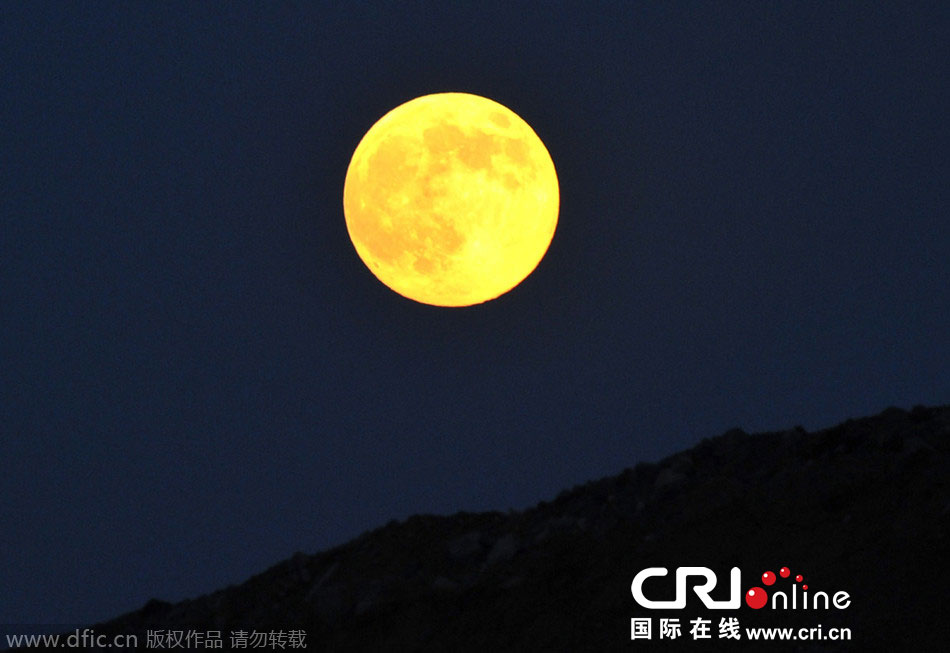 8月10日晚，一輪金燦燦的大月亮在遼寧省大連市東方升起。圖片來源：劉德斌/東方IC