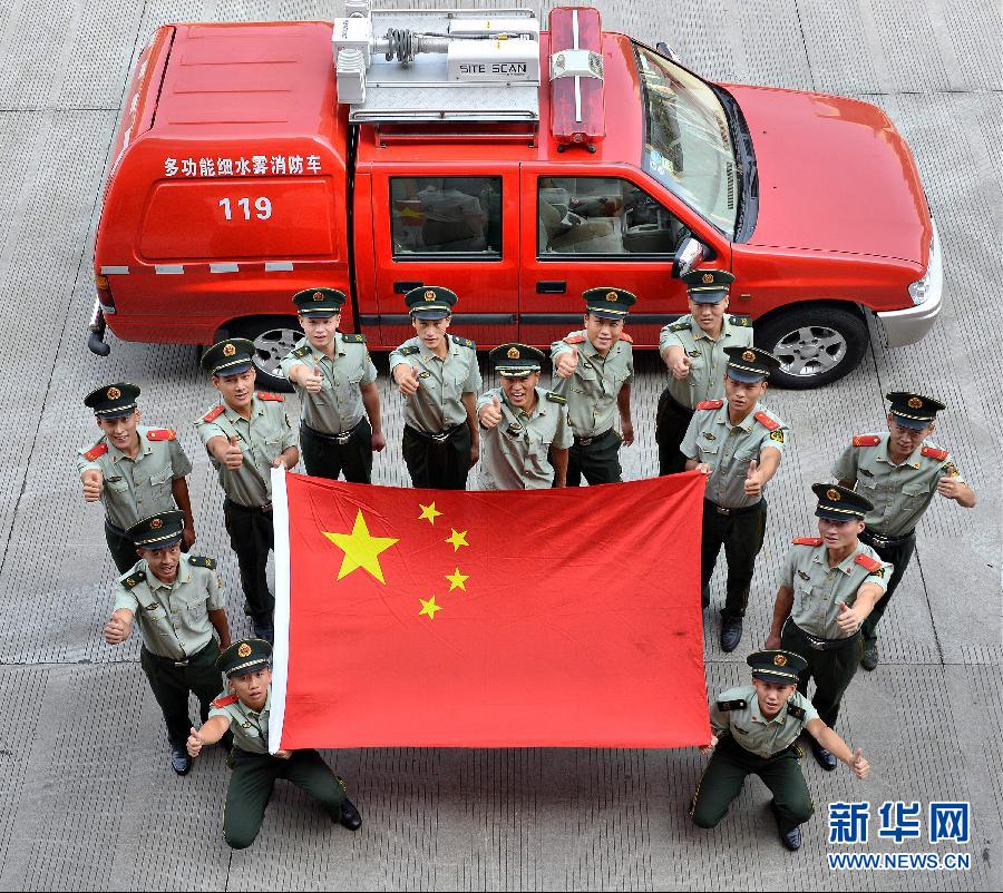  9月25日，武警浙江嘉興消防官兵與國(guó)旗合影。