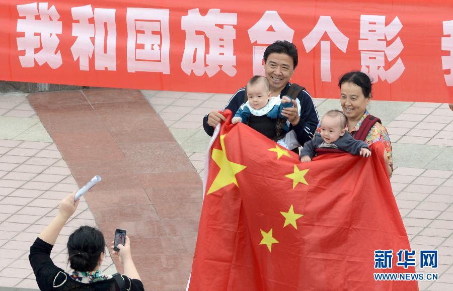 9月27日，在山東德州市中心廣場(chǎng)，市民與國(guó)旗合影。