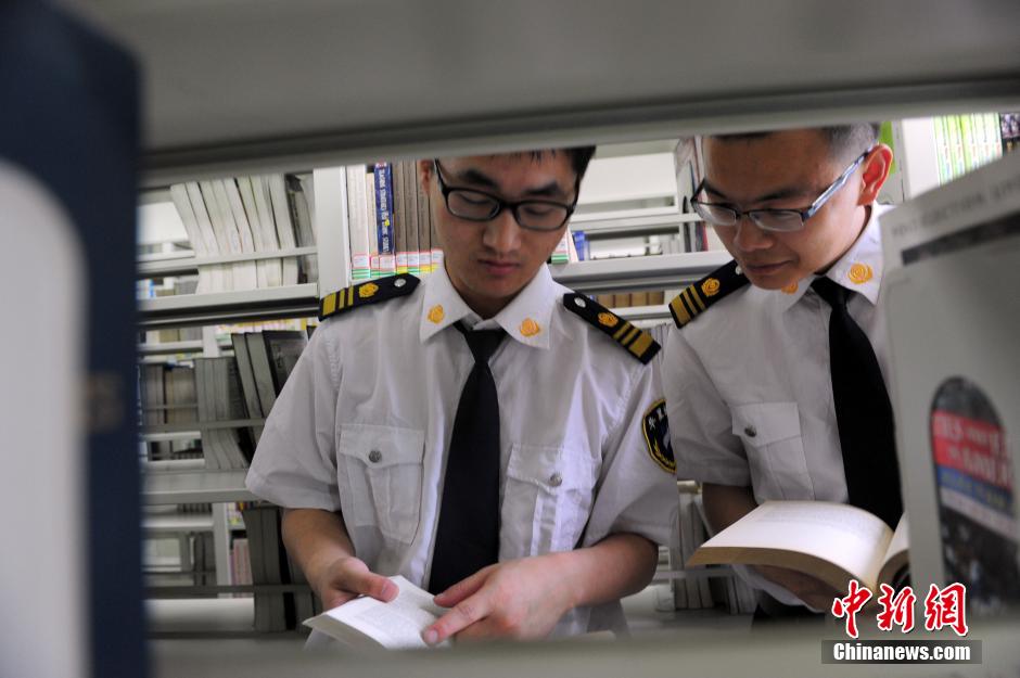 5月8日，武漢輕工大學(xué)圖書館保安吳濤與江力在圖書館交流學(xué)習(xí)。