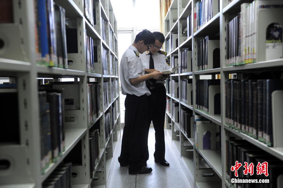 5月8日，武漢輕工大學(xué)保安吳濤與江力在圖書館交流學(xué)習(xí)。中新社發(fā) 張暢 攝