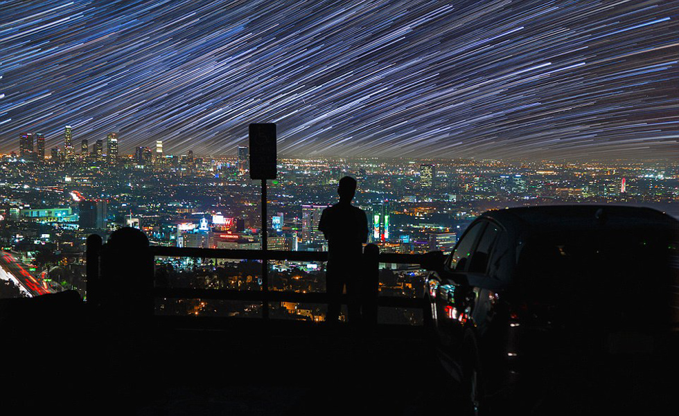 照片中，一名男子看著流星和隕星劃過天空。（網(wǎng)頁截圖）
