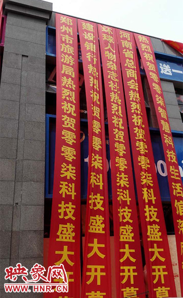 路邊一棟樓上懸掛著二三十條紅色條幅，全部是祝賀一家公司開業(yè)的。