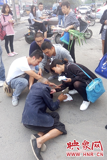 一些愛(ài)心市民在撥打了110和120后，上前給老人擦臉上的血跡。