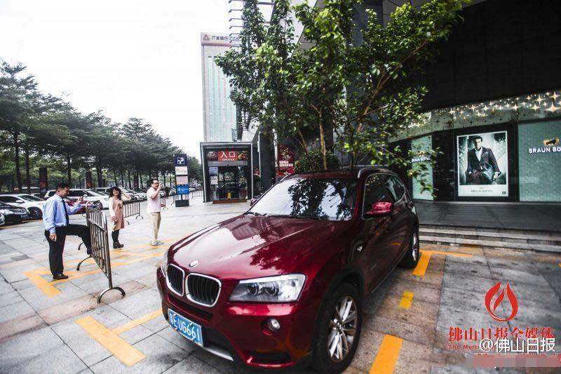 一輛停在停車位上的寶馬轎車，被墜落的樹(shù)枝砸中，樹(shù)枝徑直插入車內(nèi)，現(xiàn)場(chǎng)引發(fā)不少市民圍觀拍照。