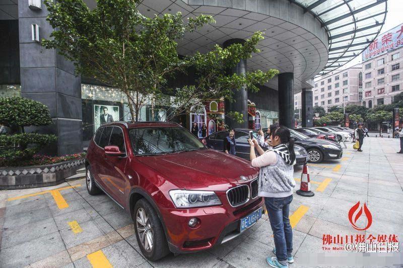 一輛停在停車位上的寶馬轎車，被墜落的樹(shù)枝砸中，樹(shù)枝徑直插入車內(nèi)，現(xiàn)場(chǎng)引發(fā)不少市民圍觀拍照。