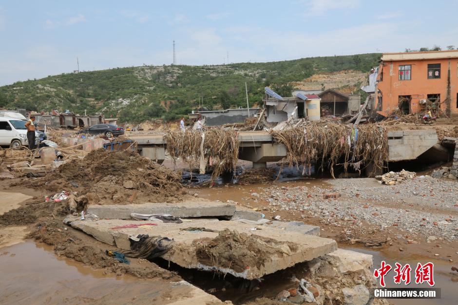 圖為洪水過后，坍塌的橋梁上遺落大量雜草。