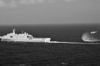 11日，抵達馬航飛機失聯(lián)海區(qū)的海軍井岡山艦與艦載直升機協(xié)同展開立體搜救行動。新華社發(fā)
