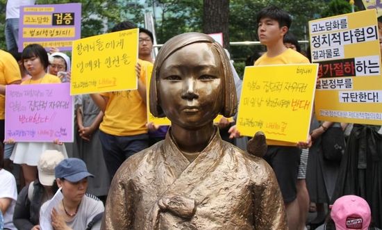 7月2日，在韓國(guó)首爾的日本駐韓國(guó)大使館前，民眾在慰安婦少女像旁手持標(biāo)語(yǔ)參加抗議活動(dòng)。