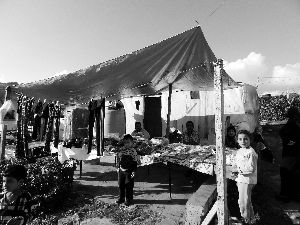 黎巴嫩一敘利亞難民營(yíng)，難民支起攤鋪賣衣服掙錢。