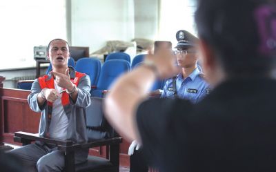 張志國在法庭上用手語回答提問。記者 蒲東峰攝