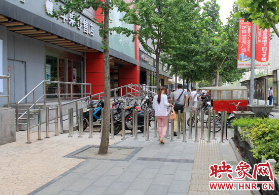 圖中道路左側(cè)的無障礙通道被鋼管隔離,右側(cè)的盲道也被侵占。
