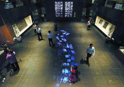 昨天，在國(guó)家典籍博物館內(nèi)，通過(guò)藝術(shù)投影技術(shù)呈現(xiàn)在展廳地面上的“漢字歷史長(zhǎng)河”，引得參觀者駐足觀看。