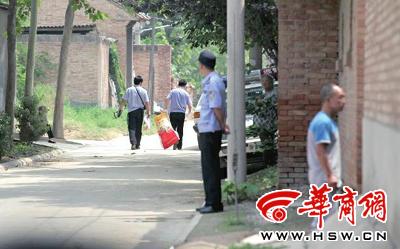昨日，西安市閻良區(qū)譚家村，警方在事發(fā)的孫某家里勘查現(xiàn)場后，將提取的物證帶走 記者 黃利健 攝