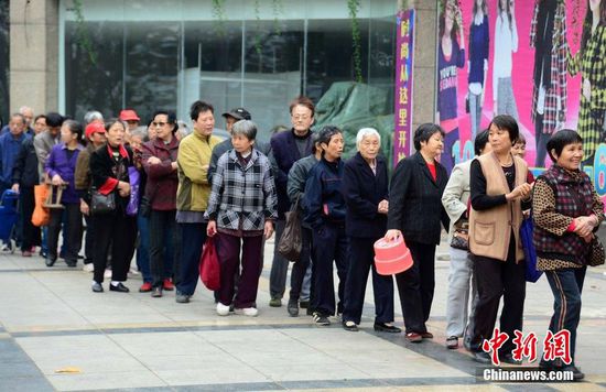 圖為10月28日，在江西九江市一家羊絨皮草服裝服飾博覽會現(xiàn)場，老人們正在頂著寒風(fēng)排隊(duì)等待領(lǐng)取10元代金劵。