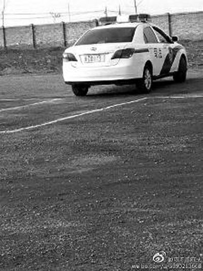一輛車牌號(hào) 為“ 陜DD173”的制式警車停在一個(gè)劃著白線的場地上，車身標(biāo)有“司法”字樣