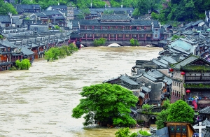 7月16日,沱江兩邊的商鋪和遠(yuǎn)處的虹橋仍淹沒(méi)在洪水中。 新華社發(fā)