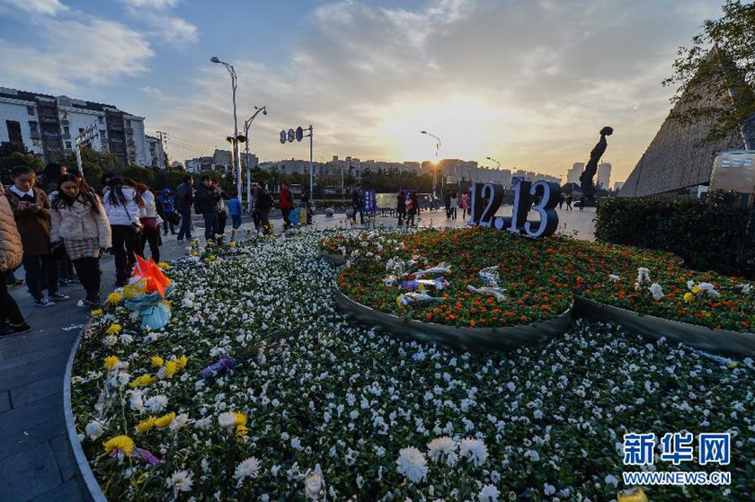 12月14日,觀眾在侵華日軍南京大屠殺遇難同胞紀(jì)念館前的“12·13”花壇上擺放鮮花祭奠遇難同胞。新華社記者 沈鵬 攝