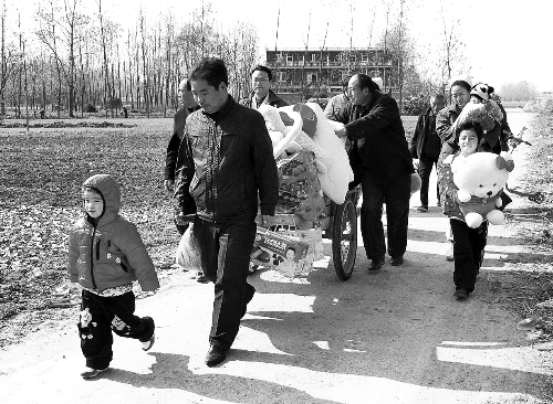 姐（左一）弟（右一護(hù)士懷中男嬰）返鄉(xiāng)，愛心捐贈滿滿一架子車。
