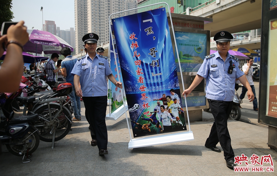 7月2日上午，鄭州市紫荊山地鐵站出入口，執(zhí)法人員抬著寫有勸導(dǎo)語(yǔ)的宣傳板，前往占道經(jīng)營(yíng)攤位“圍觀執(zhí)法”