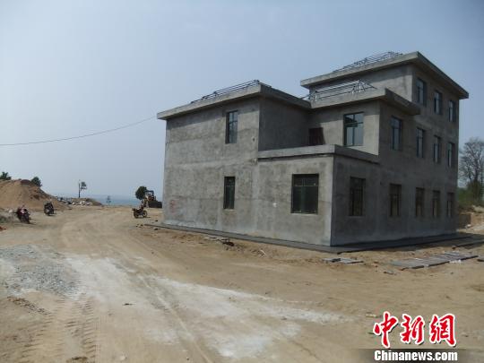 鴨河水庫庫區(qū)邊的新建別墅，一面墻上寫著“拆”，另一邊在加緊施工。吳揚(yáng)　攝
