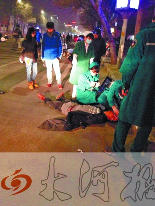 醉漢躺在地上，醫(yī)護(hù)人員對(duì)其進(jìn)行檢查。